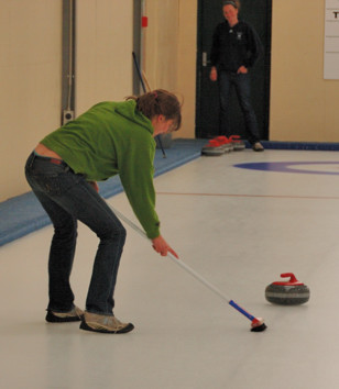 Taylor sweeping to urge on a curling stone
